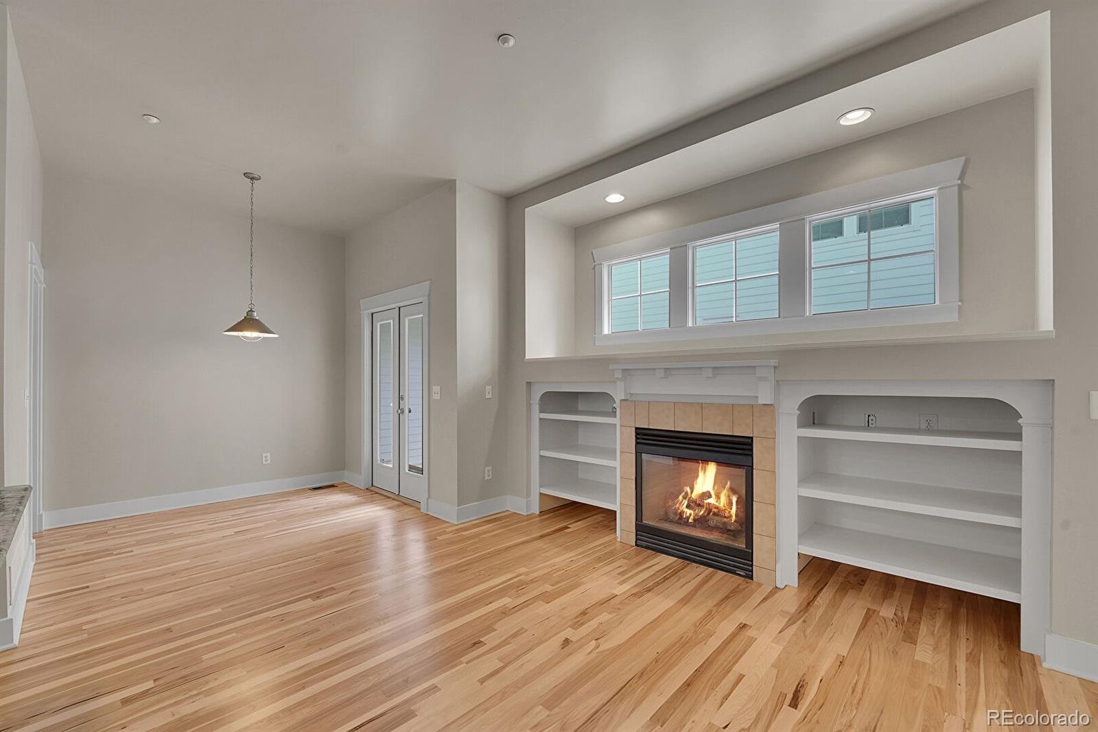 11718 Perry Street Westminster, CO 80031 - Photo 6 of 15 a view of a livingroom with a fireplace wooden floor and window