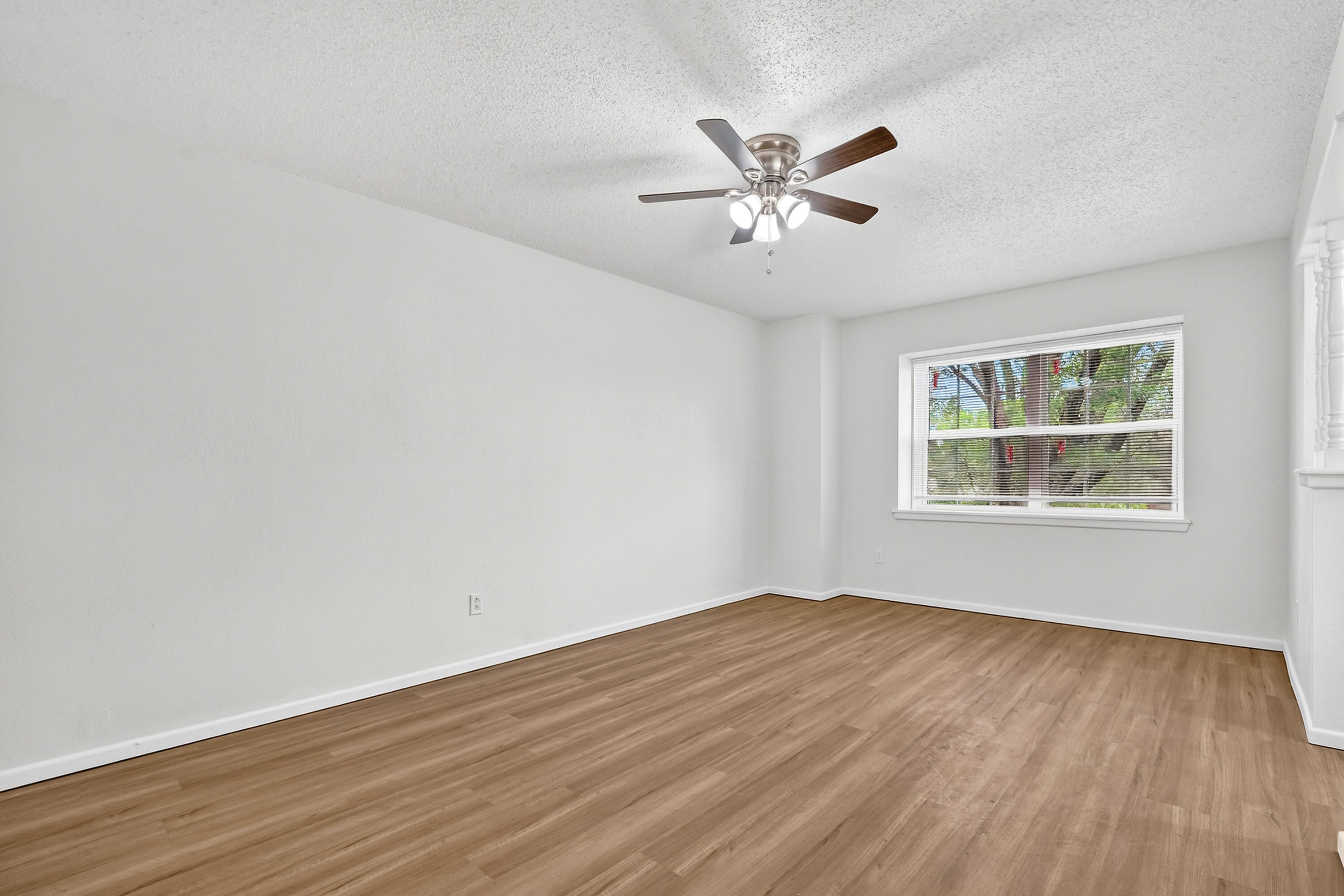 5751 38th Street Lubbock, TX 79407 - Photo 14 of 22 a view of an empty room with wooden floor and a window