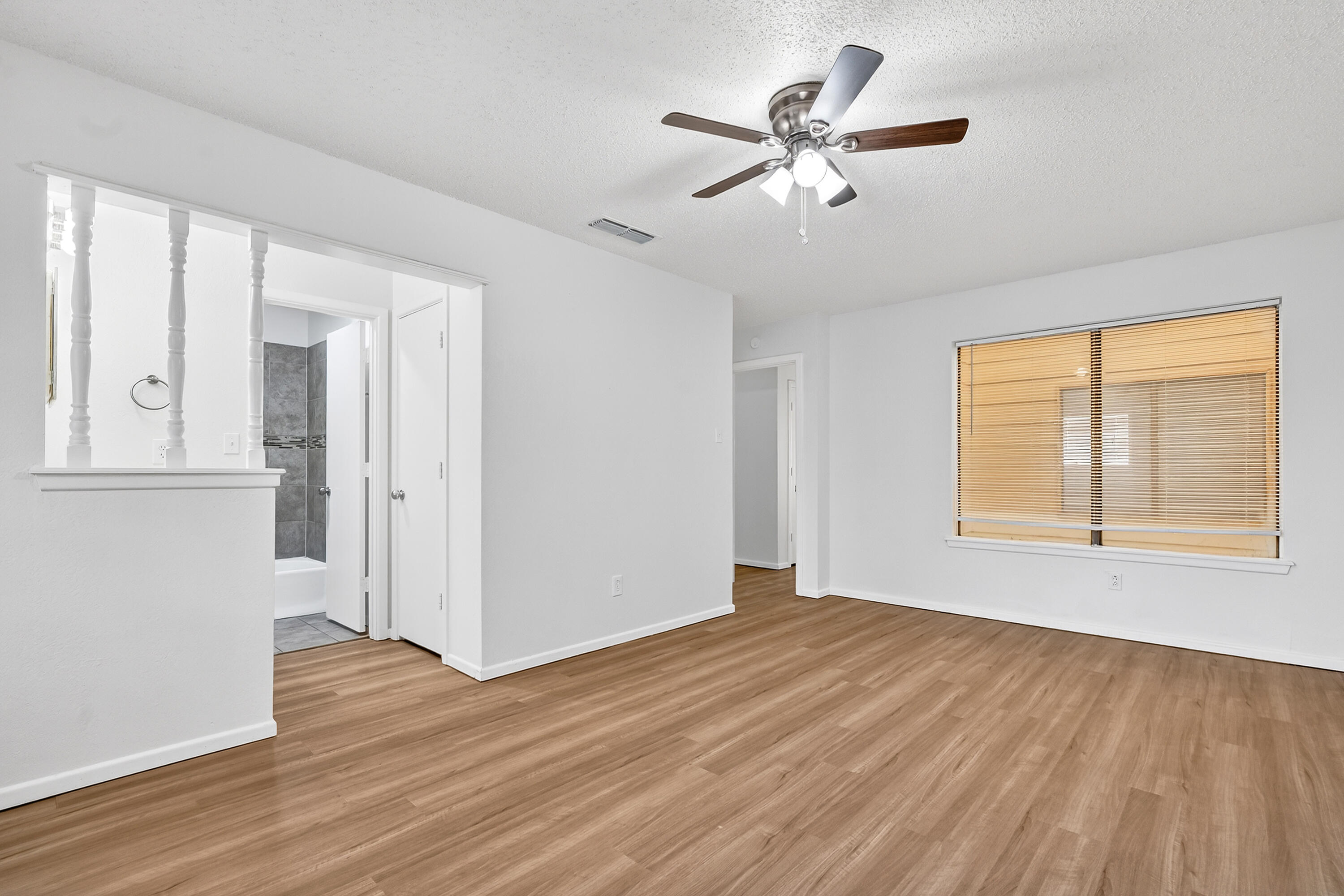 5751 38th Street Lubbock, TX 79407 - Photo 15 of 22 a view of a room with wooden floor and a ceiling fan
