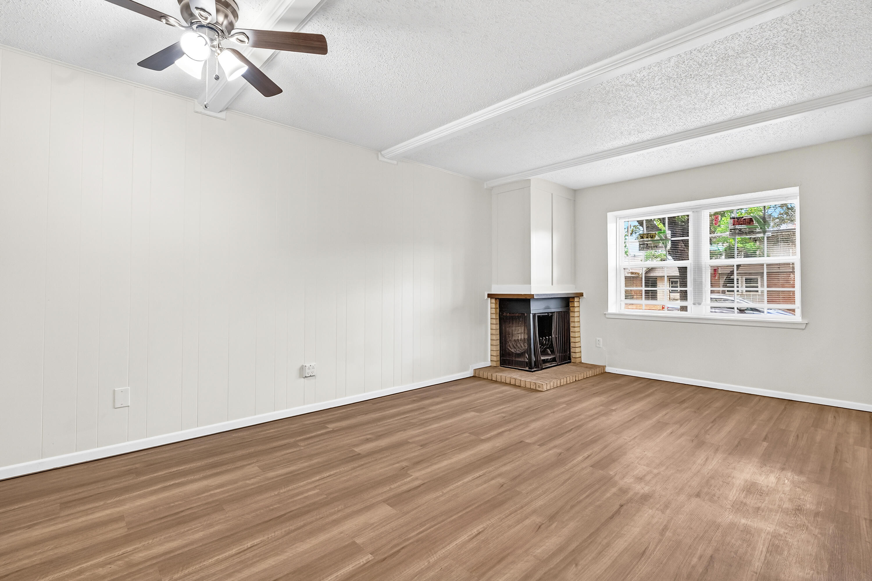 5751 38th Street Lubbock, TX 79407 - Photo 5 of 22 an empty room with wooden floor chandelier fan and windows