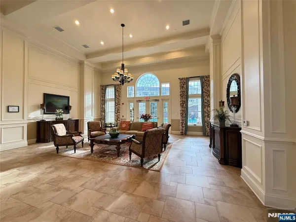 a living room with furniture chandelier and a large window