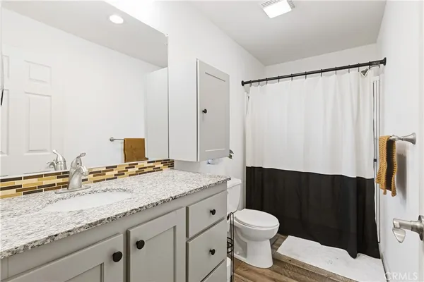 a bathroom with a granite countertop sink toilet and shower