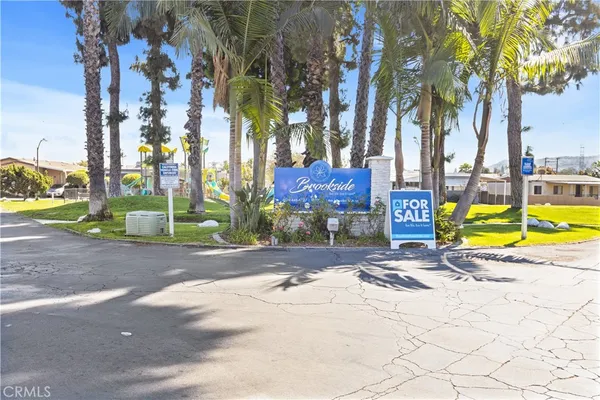 a view of a swimming pool with a lounge chair and palm trees