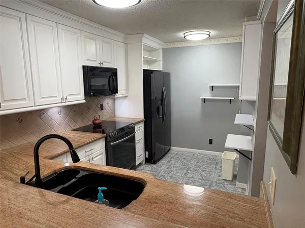 a kitchen with stainless steel appliances kitchen island granite countertop a refrigerator and a sink
