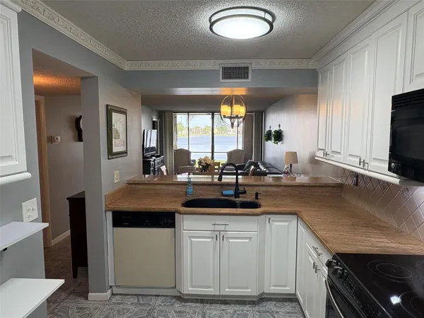 a kitchen with sink a window and chairs