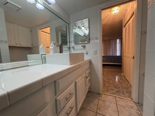 a bathroom with a sink a light fixture and a mirror