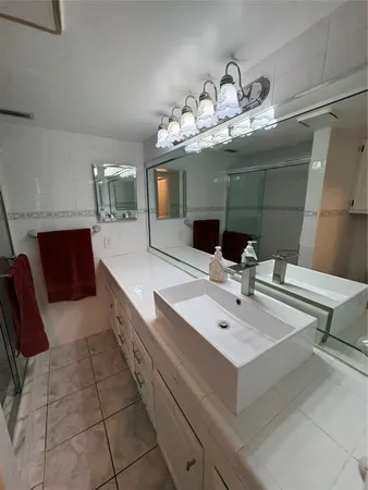 a view of a hallway with wooden floor and a bathroom