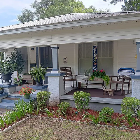 a view of a house with chairs and a table and chairs in patio