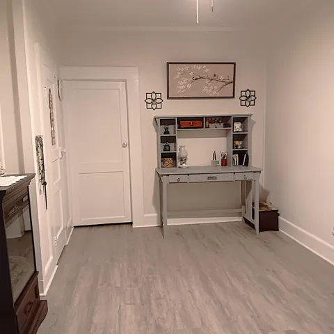 a bathroom with a vase of flowers and a toilet