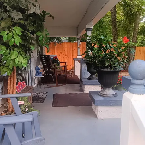 a view of a patio with table and chairs potted plants