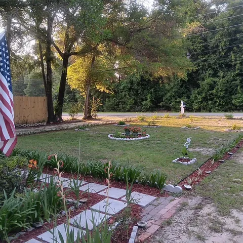 a front view of a house with a yard and green space