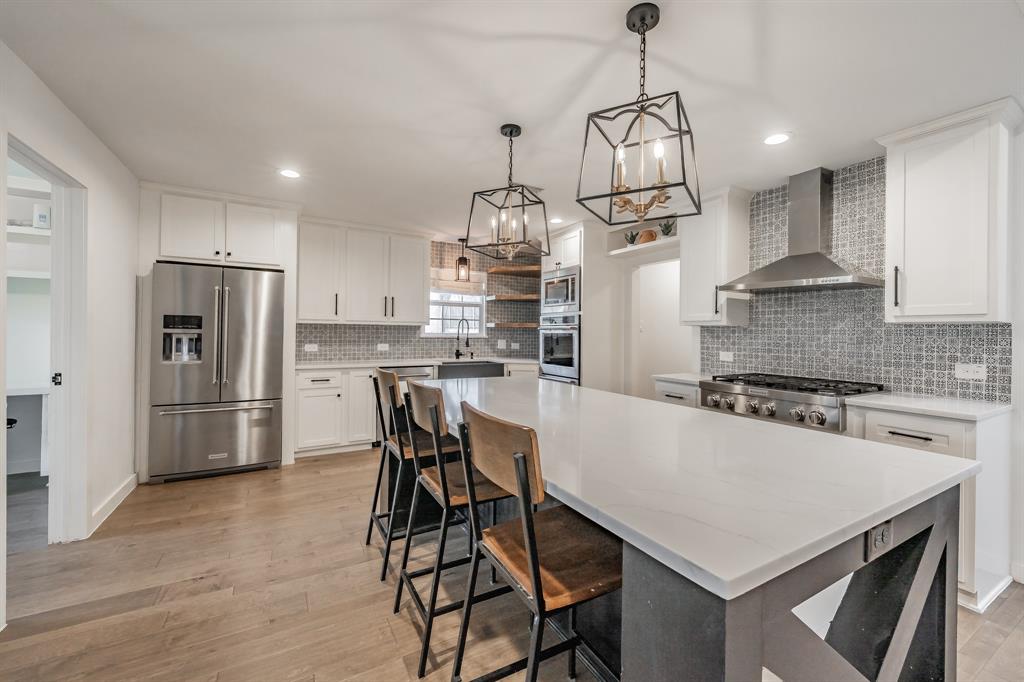 322 Canyon Ridge Drive Richardson, TX 75080 - Photo 13 of 33 a kitchen with stainless steel appliances a stove a refrigerator a sink a stove and white cabinets