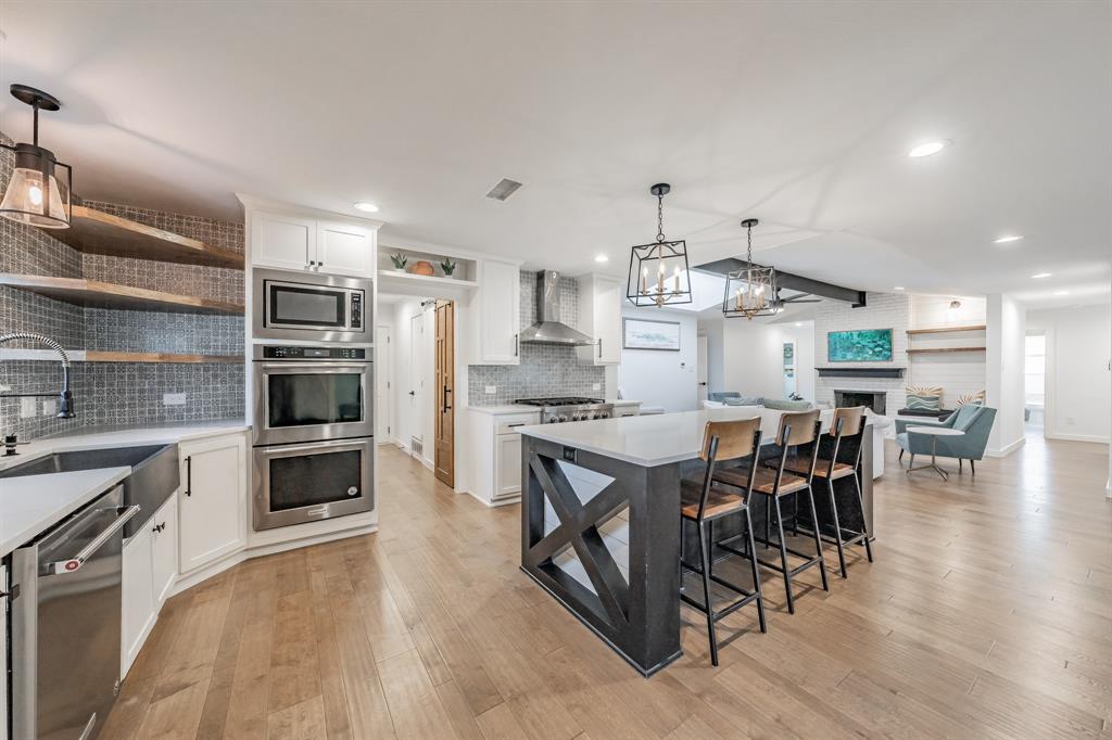 322 Canyon Ridge Drive Richardson, TX 75080 - Photo 14 of 33 a kitchen with kitchen island a large counter top stainless steel appliances and cabinets