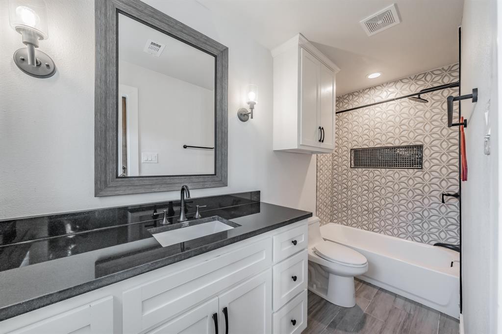 322 Canyon Ridge Drive Richardson, TX 75080 - Photo 25 of 33 a bathroom with a sink a toilet a mirror and shower