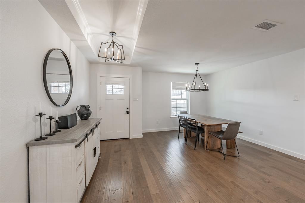322 Canyon Ridge Drive Richardson, TX 75080 - Photo 4 of 33 a view of a dining room with furniture a chandelier and wooden floor