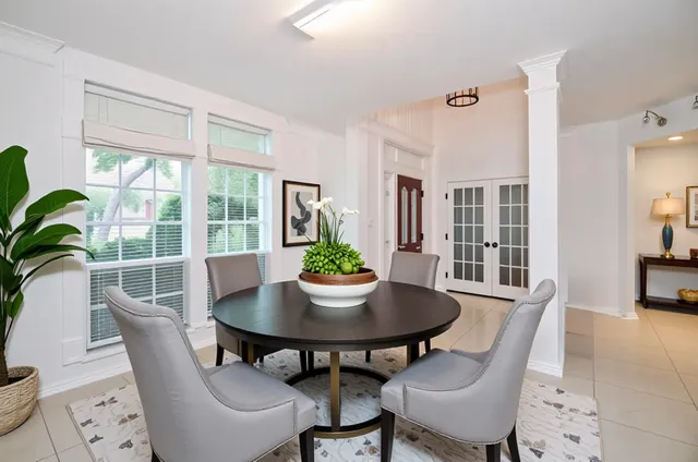 a dining room with furniture potted plants and wooden floor