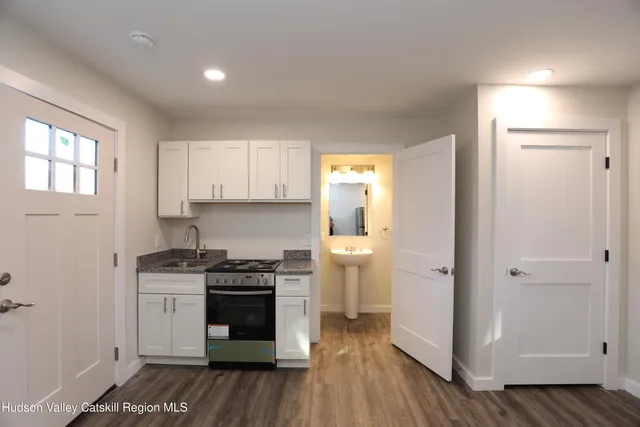 a kitchen with a sink and wooden floor