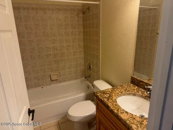 a bathroom with a granite countertop toilet sink and shower