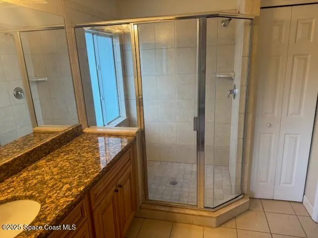 a bathroom with a granite countertop shower and a sink