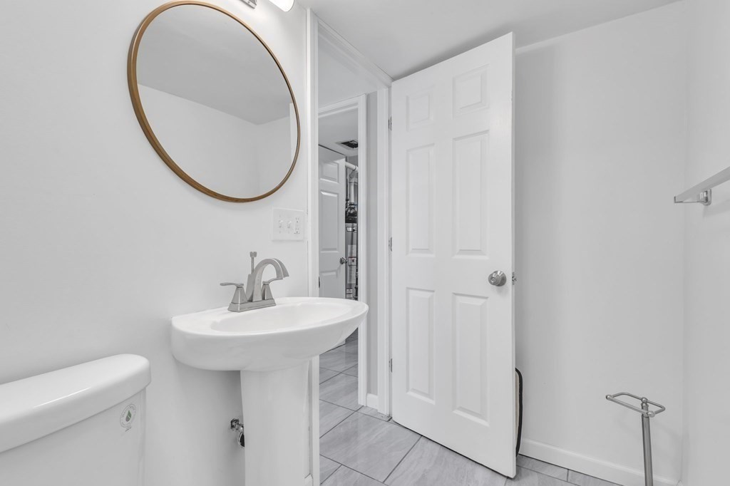 1638 Parker Street Springfield, MA 01128 - Photo 29 of 36 a bathroom with a sink a mirror and a toilet