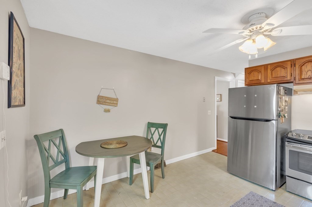 1638 Parker Street Springfield, MA 01128 - Photo 8 of 36 a kitchen with stainless steel appliances refrigerator dining table and chairs
