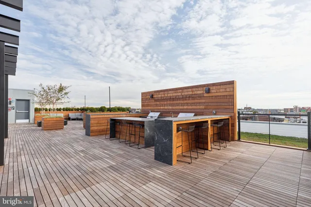 a terrace of a house with barbeque oven and seating space