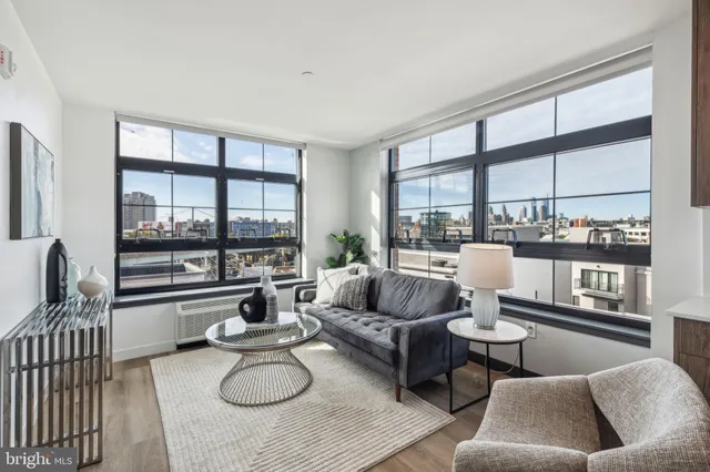 a kitchen with stainless steel appliances a dining table chairs refrigerator and sink