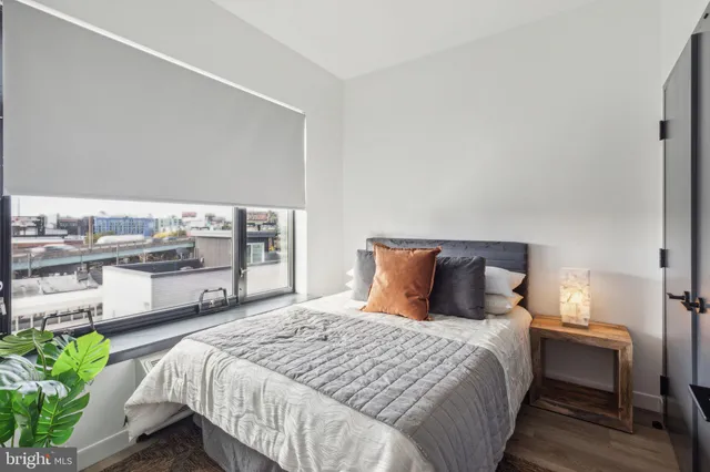 a bedroom with a large bed and a potted plant