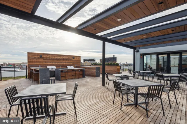 a view of a patio with dining table and chairs with wooden floor and fence