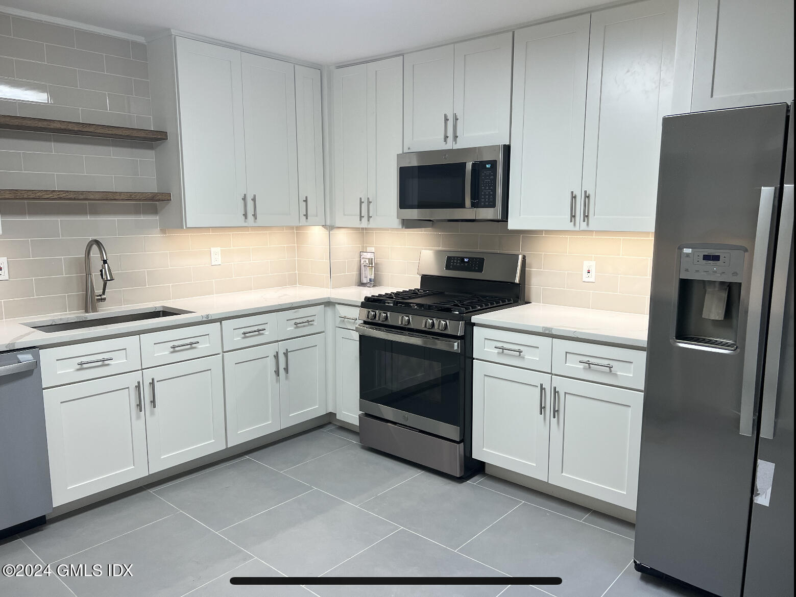 a kitchen with white cabinets and white appliances