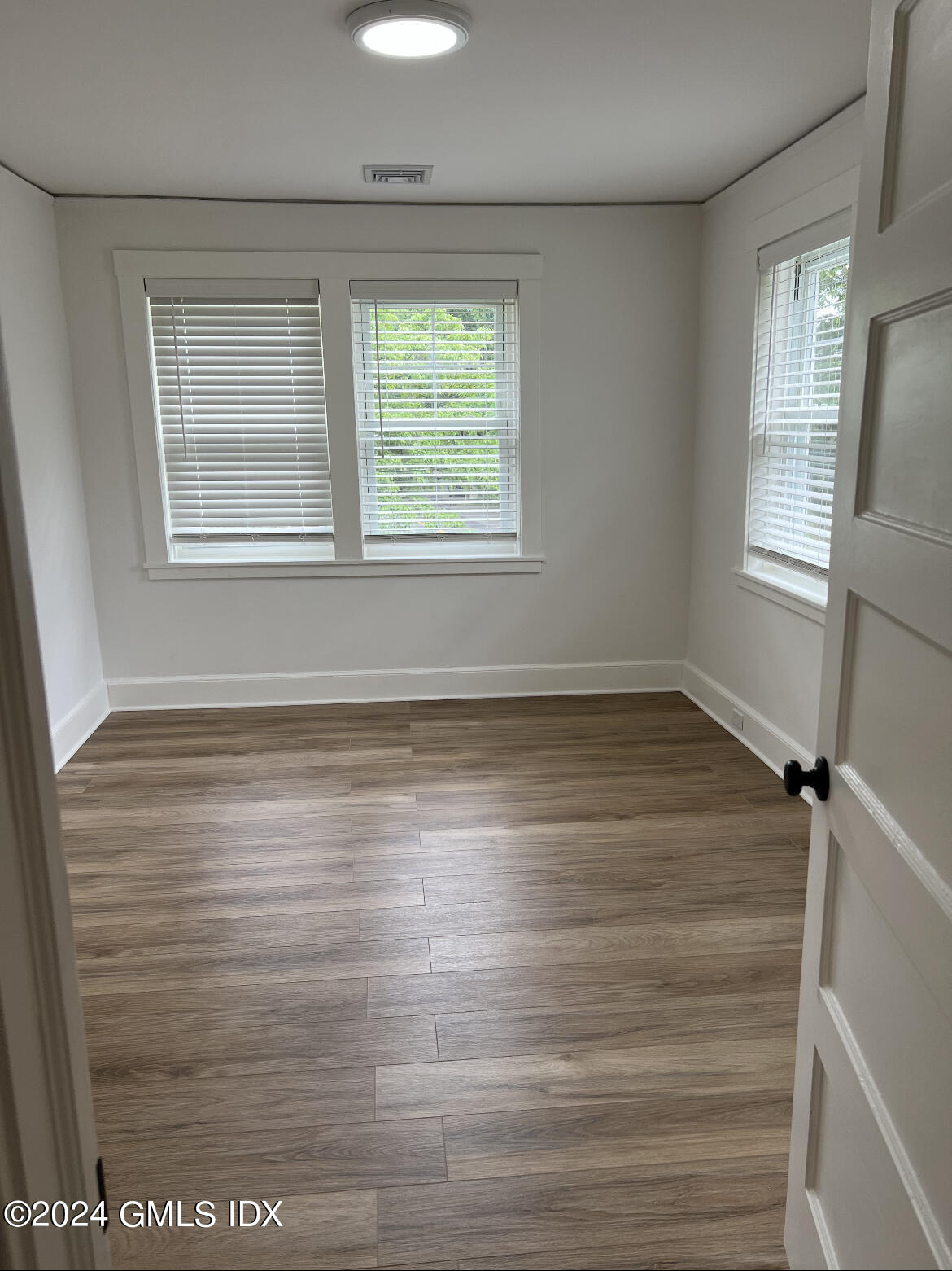 45 Bible Street, Unit 2 Cos Cob, CT 06807 - Photo 6 of 12 an empty room with wooden floor and windows