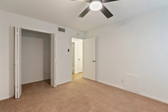 an empty room with chandelier fan