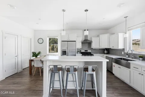 a kitchen with kitchen island granite countertop a sink a counter space appliances and cabinets