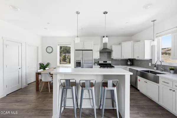 a kitchen with kitchen island granite countertop a sink a counter space appliances and cabinets
