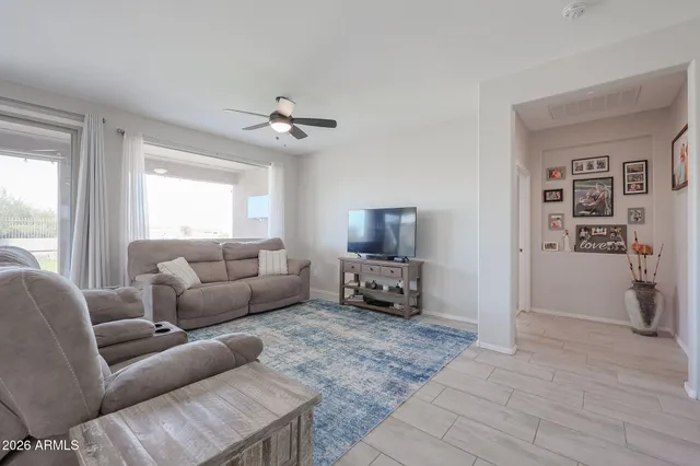 a living room with furniture a ceiling fan and a window