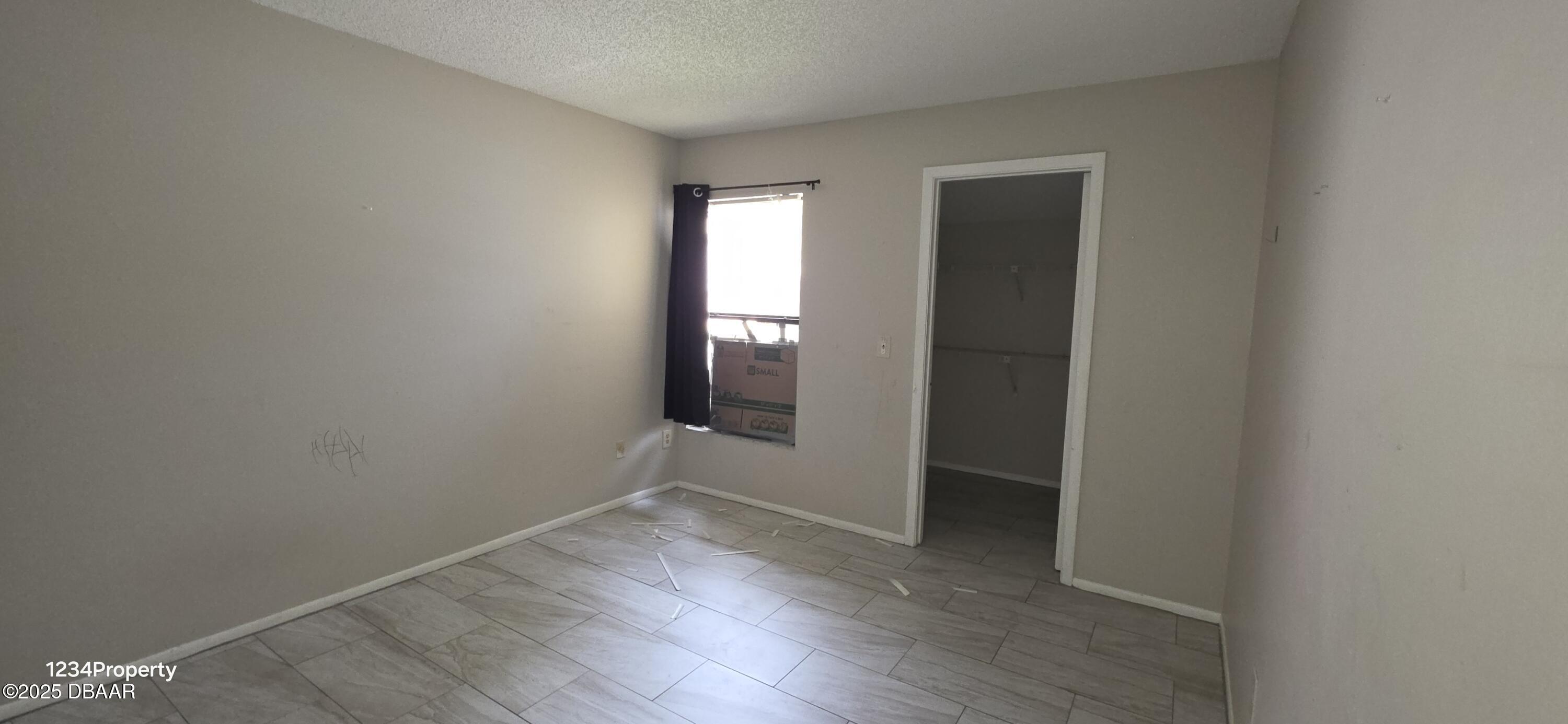 12136 Sand Pebble Way Orlando, FL 32824 - Photo 8 of 14 an empty room with wooden floor and windows