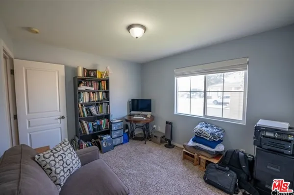 a living room with furniture a bookshelf and a window
