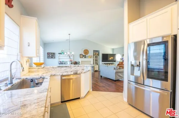a kitchen with stainless steel appliances granite countertop a refrigerator a stove a sink and a refrigerator