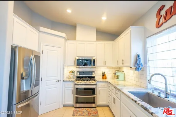 a kitchen with stainless steel appliances kitchen island granite countertop a refrigerator stove and sink