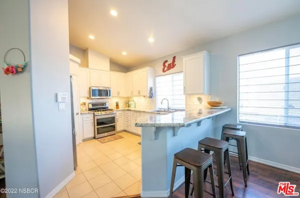 a kitchen with granite countertop counter space a sink appliances and cabinets