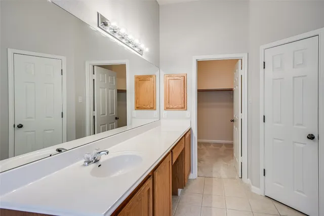 a spacious bathroom with a double vanity sink a mirror and a shower