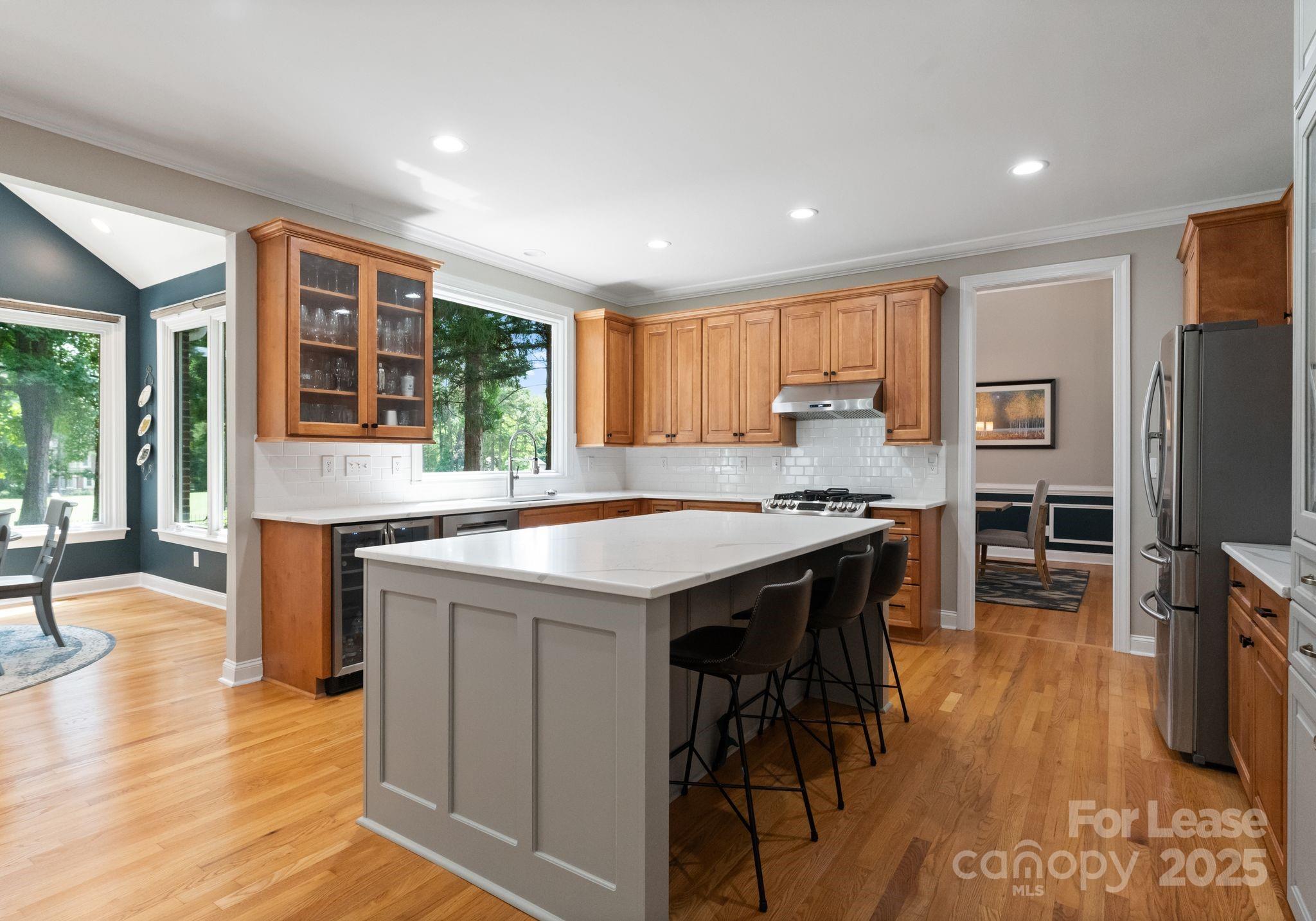 18807 Dembridge Drive Davidson, NC 28036 - Photo 11 of 35 a kitchen with granite countertop a stove a sink a dining table and chairs with wooden floor