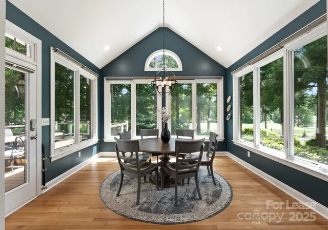 a dining room with furniture large windows and a chandelier