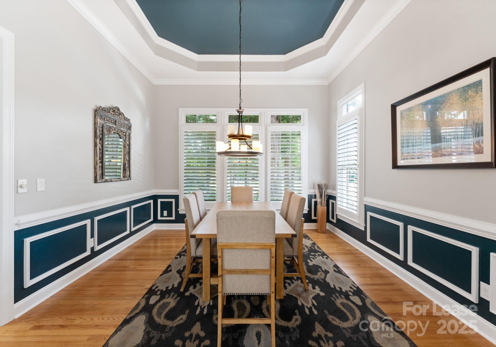18807 Dembridge Drive Davidson, NC 28036 - Photo 17 of 35 a dining room with wooden floor a chandelier a wooden table and chairs