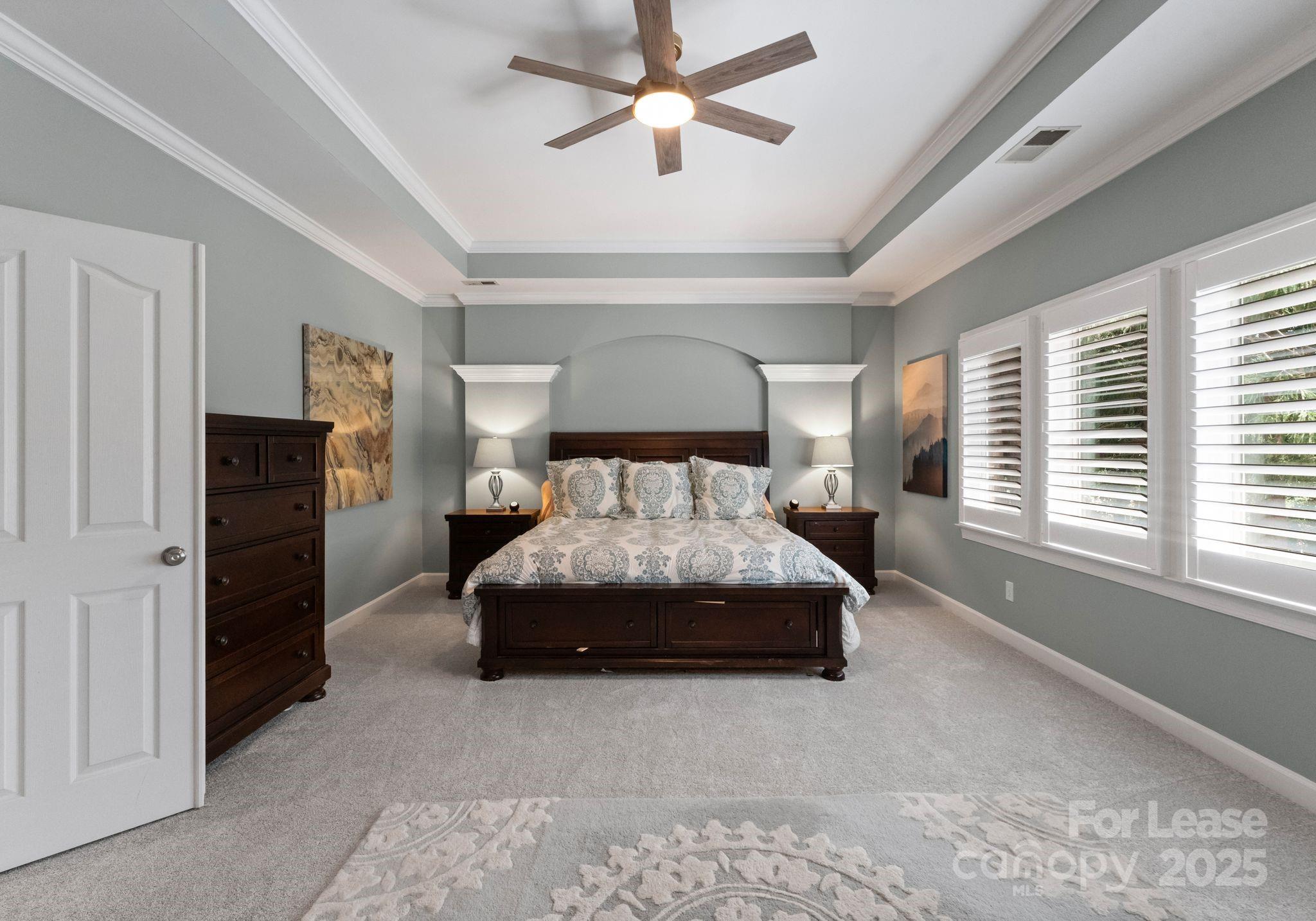18807 Dembridge Drive Davidson, NC 28036 - Photo 22 of 35 a spacious bedroom with a bed and a chandelier