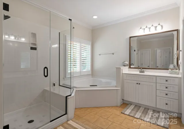 a spacious bathroom with a double vanity sink a mirror a bathtub and window
