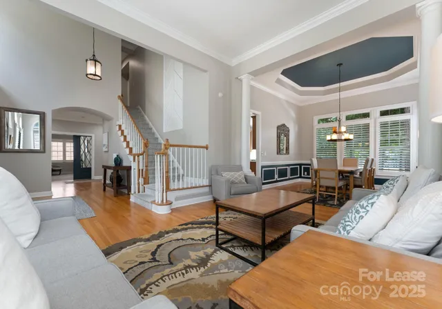 a living room with furniture wooden floor and a large window