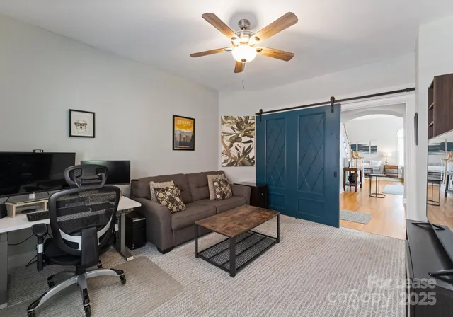 a living room with furniture and a view of kitchen