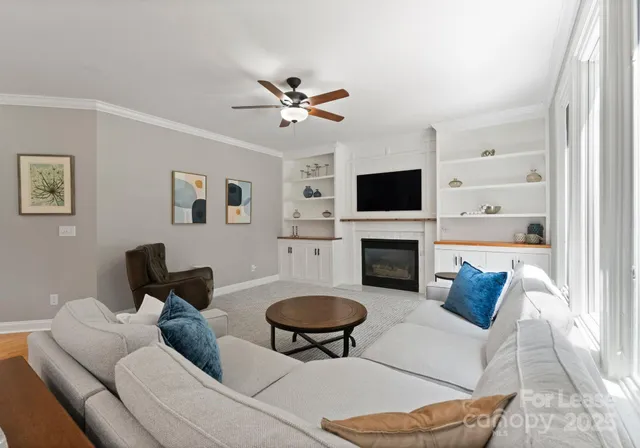 a living room with furniture a fireplace and a flat screen tv