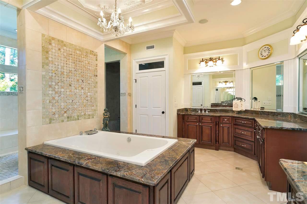 302 Annandale Drive Cary, NC 27511 - Photo 14 of 30 a bathroom with a granite countertop sink a large mirror and a bathtub